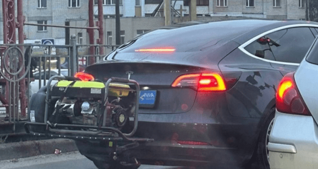 Tesla car spotted on city street with generator tacked to the back of the car.